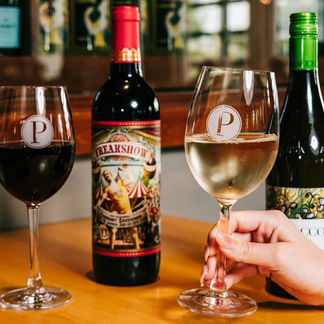 Red and white wine glasses with bottles for half-off wine special