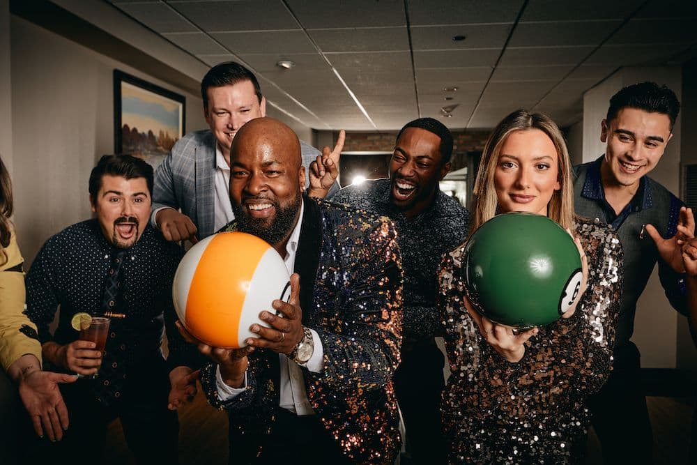 Friends bowling in cocktail attire and having a great time at Pinstripes.