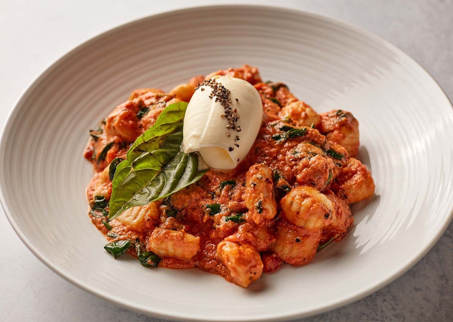 Gnocchi and pasta in vodka sauce with fresh basil from Pinstripes.