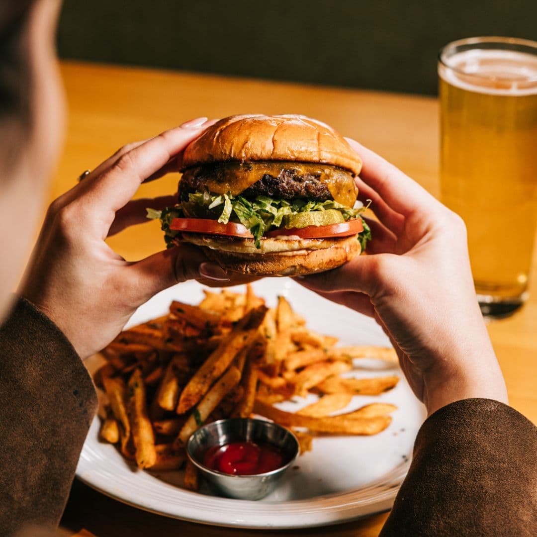 Burger with seasoned fries and a draft beer for Tuesday combo special