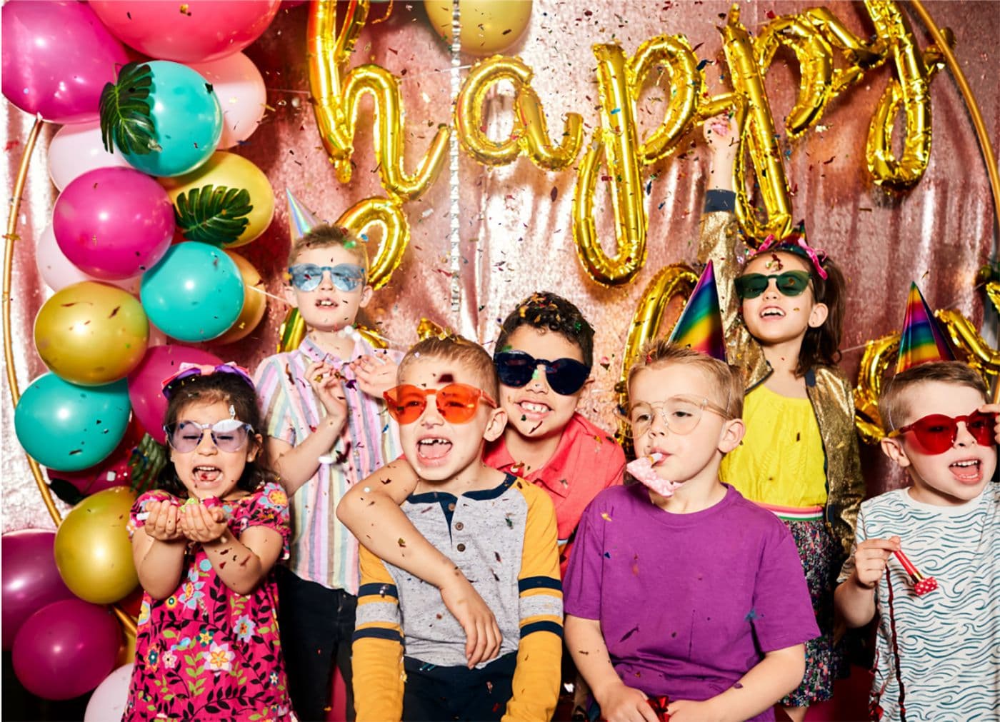 Little kids celebrating a birthday party together and having a good time.